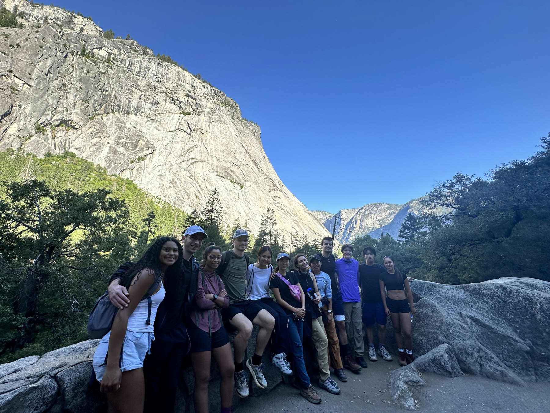 Self-Improvement Club members gathered on a Yosemite trail beneath a granite cliff